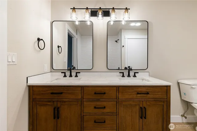 a bathroom with a double vanity sink and a mirror
