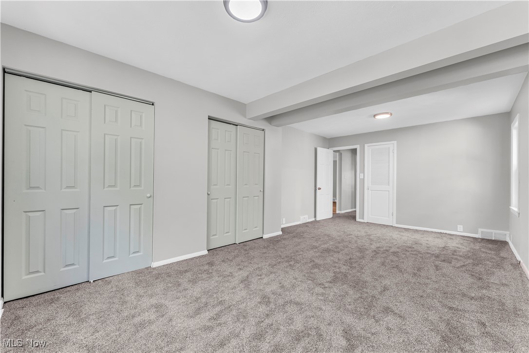 2425 Canterbury Road Cleveland Heights, OH 44118 - Photo 24 of 33 Unfurnished bedroom featuring multiple closets, beam ceiling, and carpet flooring