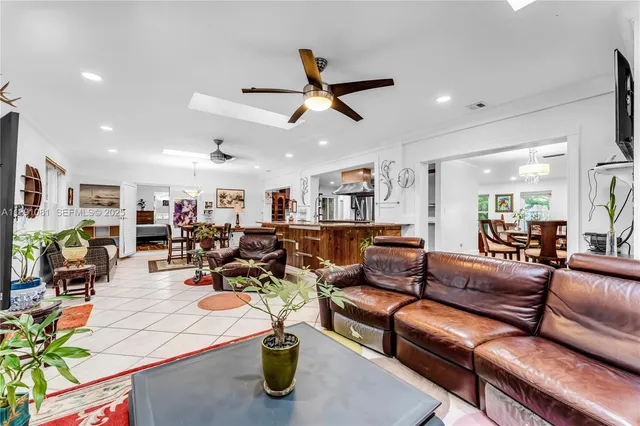 a living room with furniture kitchen view and a chandelier