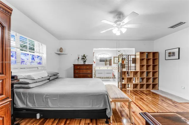 a bedroom with a bed and a bookshelf with wooden floor