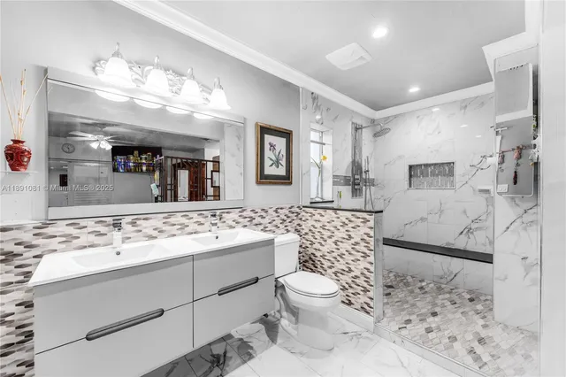 a bathroom with a sink a toilet and shower