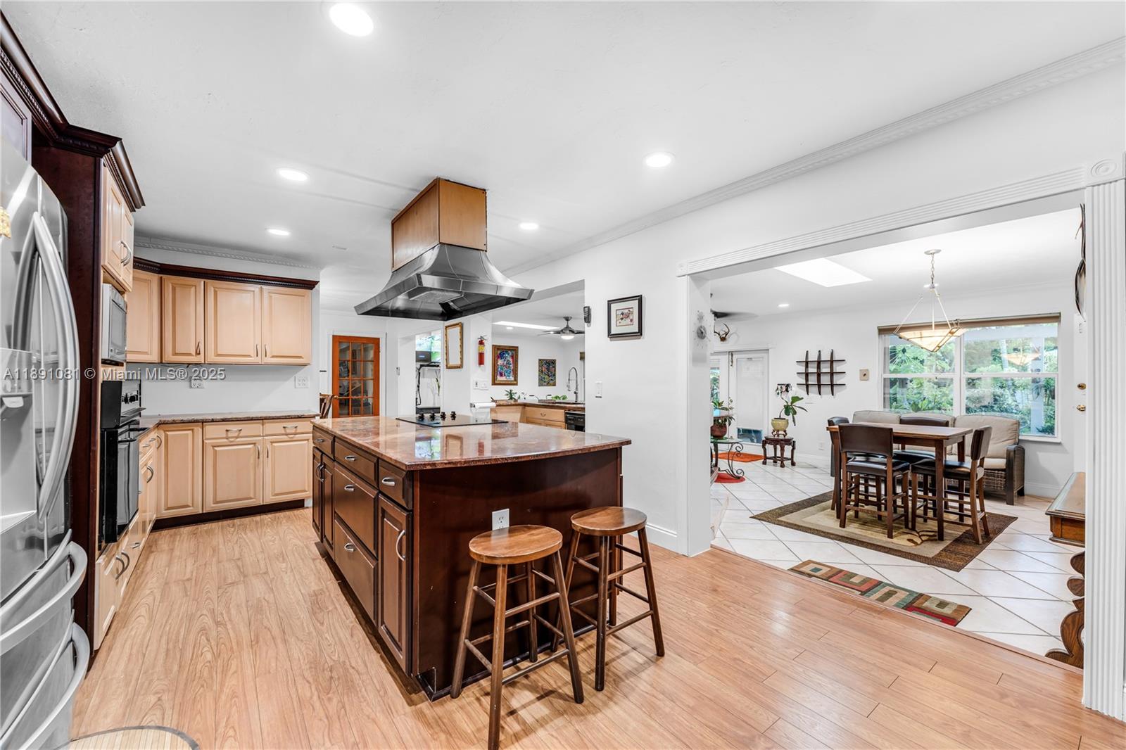 9081 Southwest 140th Street Miami, FL 33176 - Photo 8 of 29 a kitchen with stainless steel appliances granite countertop a refrigerator a sink dishwasher a dining table and chairs with wooden floor