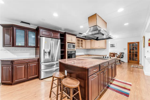 a kitchen with stainless steel appliances granite countertop a stove a refrigerator and a dining table