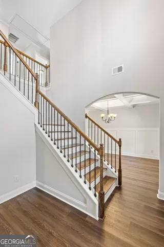 an empty room with wooden floor fireplace and windows