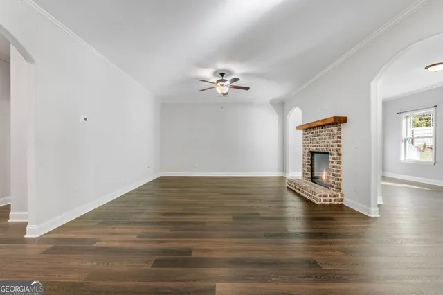 a view of a kitchen with a fireplace a ceiling fan and wooden floor
