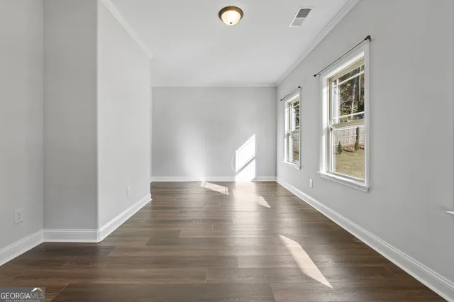 a large kitchen with stainless steel appliances granite countertop a stove a refrigerator a sink and white cabinets with wooden floor