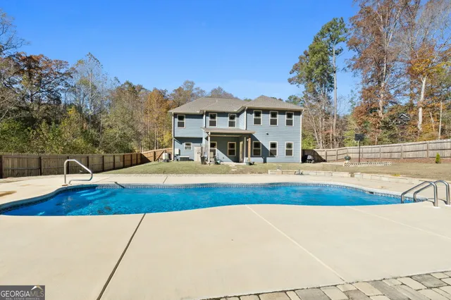 a view of a house with pool and a yard