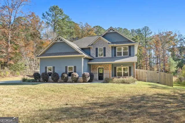 a front view of house with yard and trees around