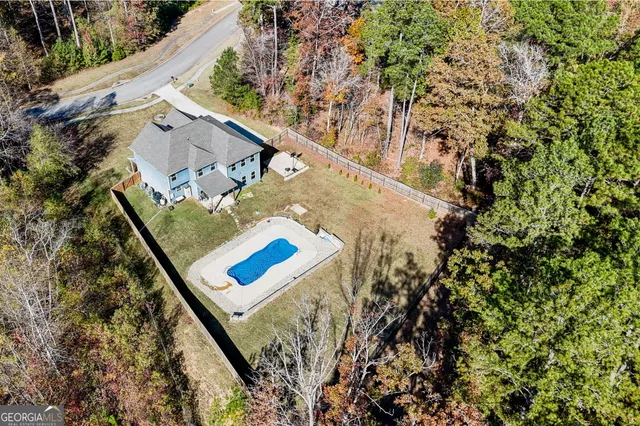 a front view of a house with garden and two chairs