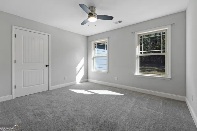 a view of a white house with a yard and sitting area