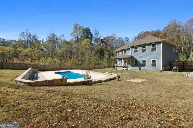 an aerial view of a house with a yard and large trees