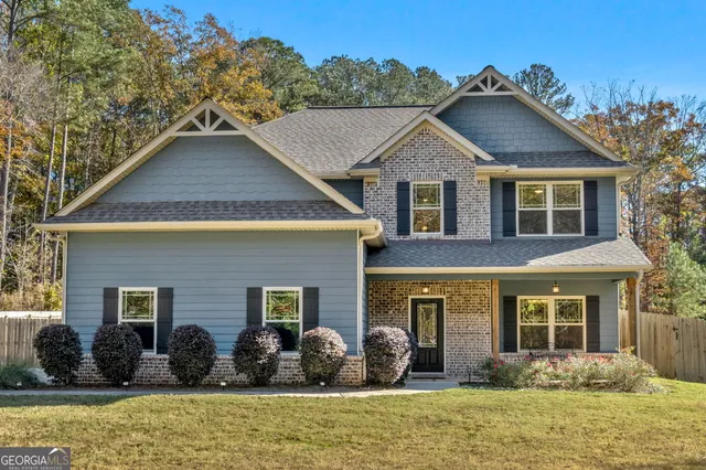 a front view of a house with a large window and potted plants