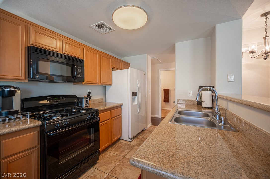 7701 West Robindale Road, Unit 274 Las Vegas, NV 89113 - Photo 13 of 38 This functional kitchen features granite counters, offering a seamless blend of style and utility.