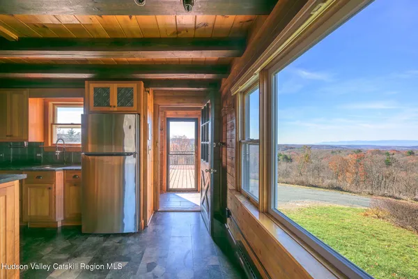 a view of a living room with kitchen view and wooden floor