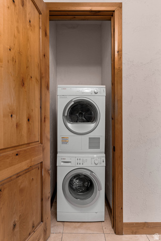 2464 East Granite Way St. George, UT 84790 - Photo 61 of 106 Mudroom has a stacked laundry behind door with light tile patterned floors and stacked washer / dryer