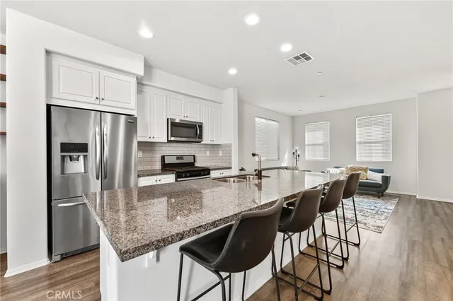 a kitchen with granite countertop a center island stainless steel appliances cabinets and a counter top space