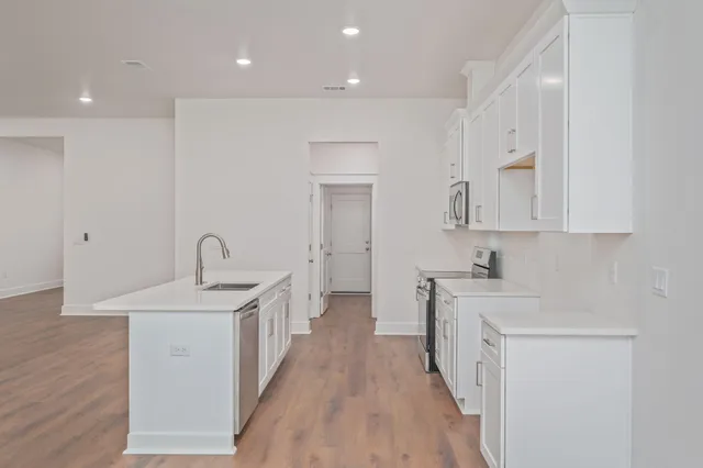 a kitchen with sink a stove and cabinets