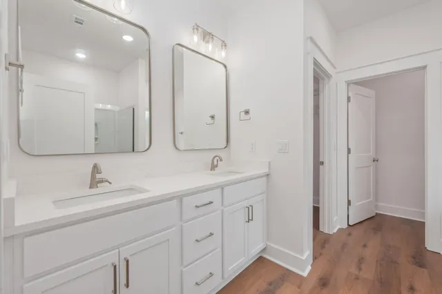 a bathroom with double vanity sink and a mirror