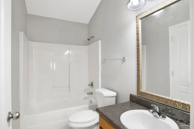 a bathroom with a toilet a sink a mirror a bathtub and shower