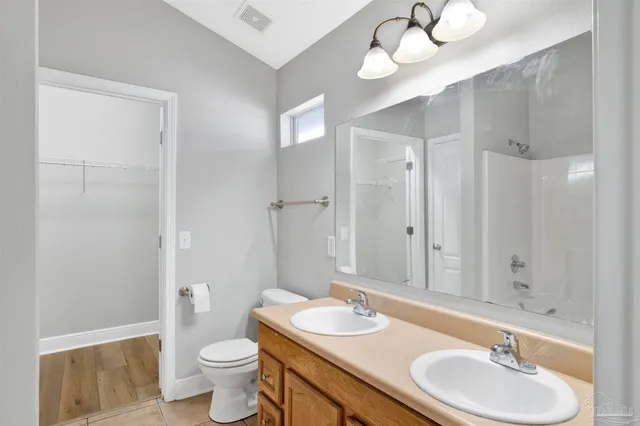 a bathroom with a sink vanity granite and toilet