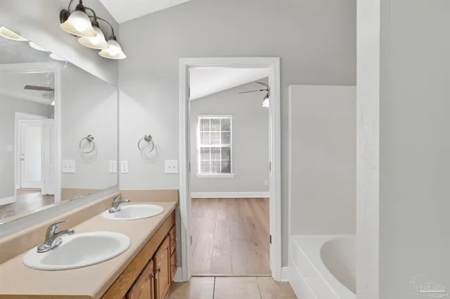 a bathroom with a sink a tub and a mirror