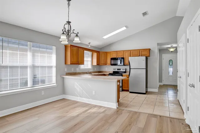 a kitchen with stainless steel appliances granite countertop a refrigerator a sink dishwasher a refrigerator and white cabinets with wooden floor