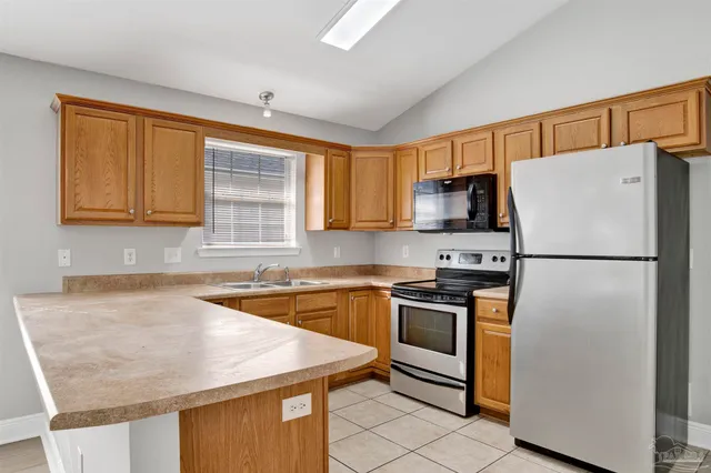 a kitchen with stainless steel appliances granite countertop a refrigerator sink stove microwave and cabinets