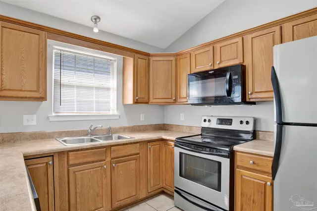 a kitchen with stainless steel appliances a stove microwave and sink
