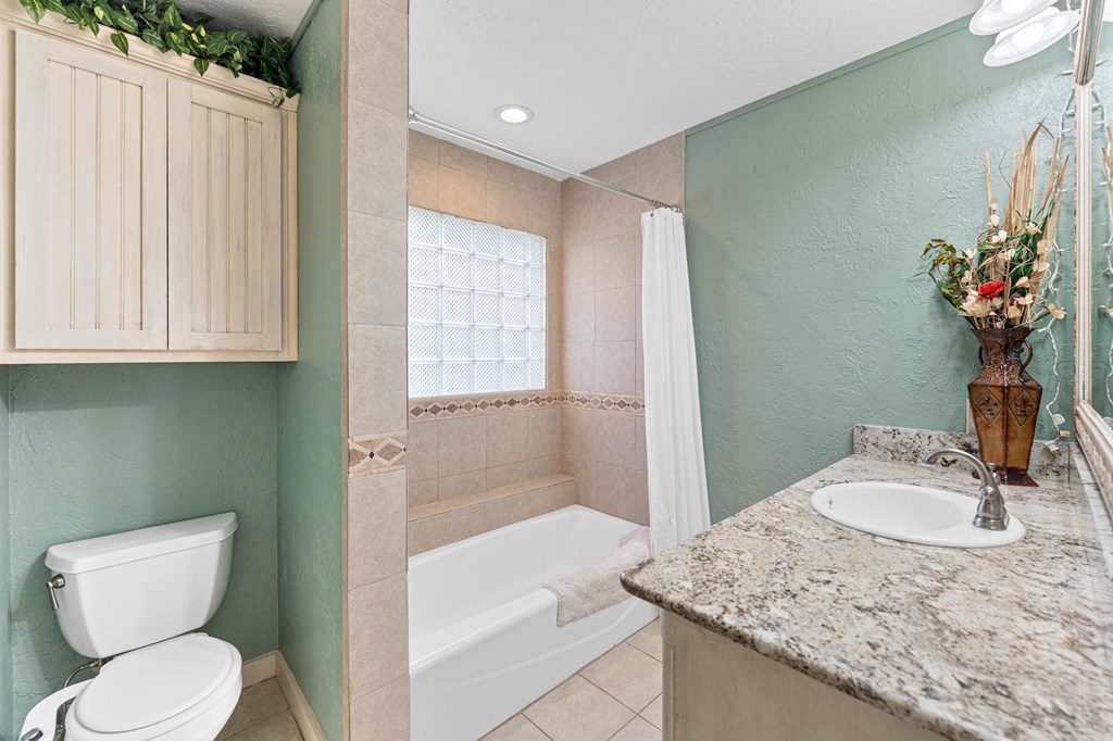 43 High Street Road Comfort, TX 78013 - Photo 46 of 90 a bathroom with a granite countertop sink a toilet and mirror