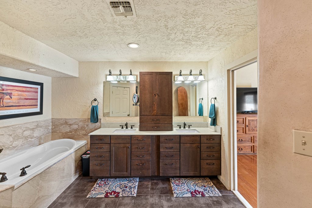 43 High Street Road Comfort, TX 78013 - Photo 58 of 90 a bathroom with a bathtub double vanity sink and a mirror