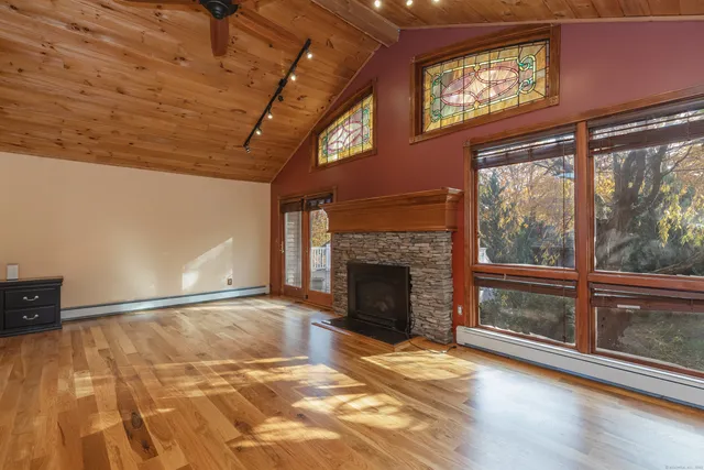 a view of an empty room with a fireplace and a window