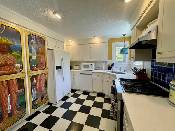 a kitchen with a checkered floor and white cabinets