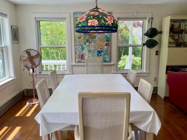 a view of a dining room with furniture a chandelier and wooden floor