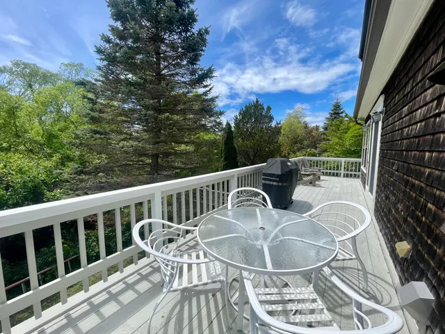 a view of a chair and table on the deck