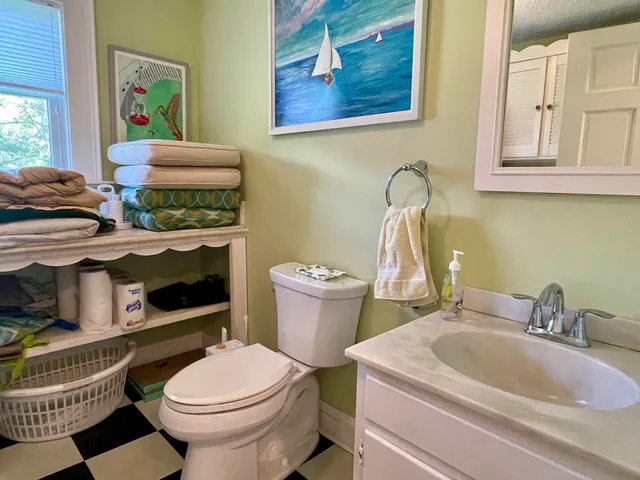 a bathroom with a sink a toilet and a mirror