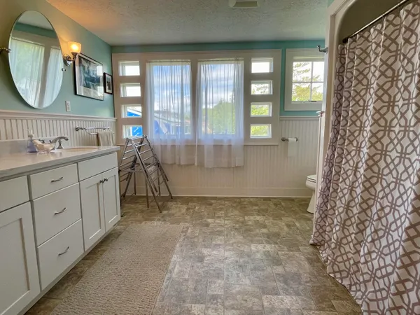 a bathroom with a granite countertop sink a mirror a vanity and a shower