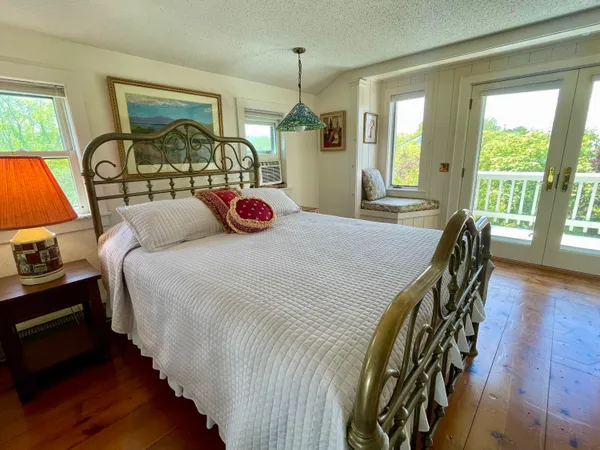 a bedroom with a bed a dresser next to a window