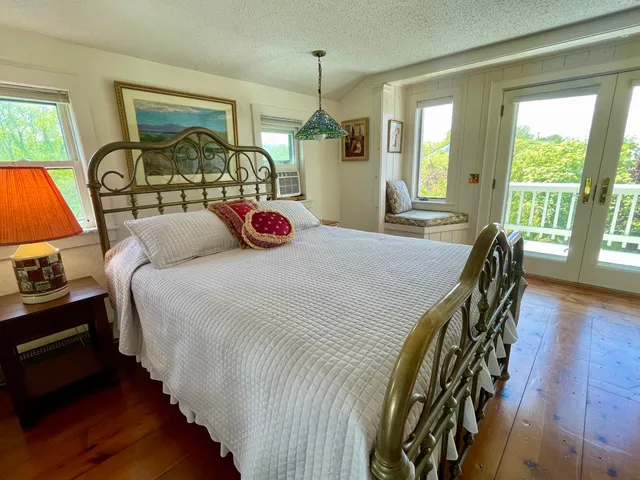 a bedroom with a bed a dresser next to a window