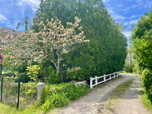 a view of a house with brick walls and a flower garden