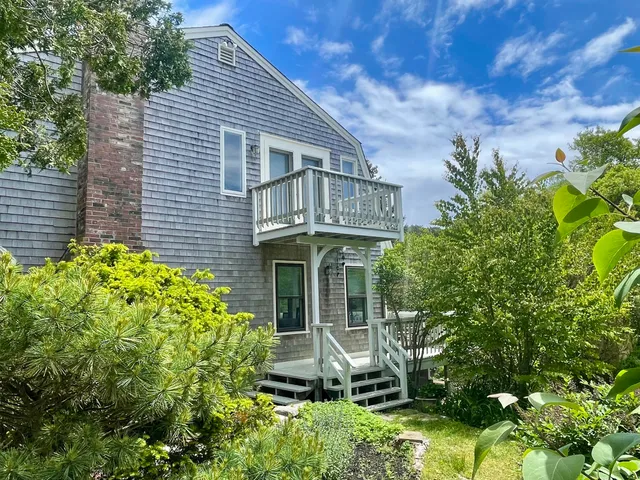 a backyard of a house with a yard and outdoor seating