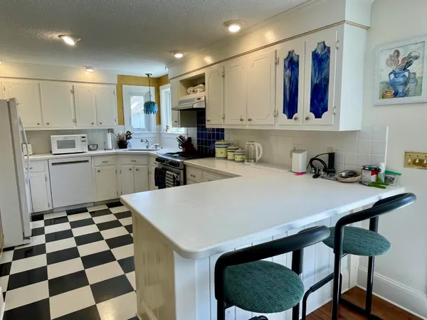 a kitchen with a sink a refrigerator and cabinets