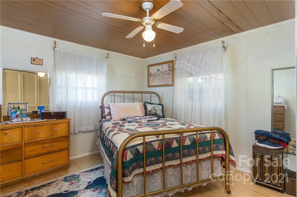 10200 Highway 23 Cheboygan, MI 49721 - Photo 13 of 14 a bedroom with a bed a dresser and potted plants