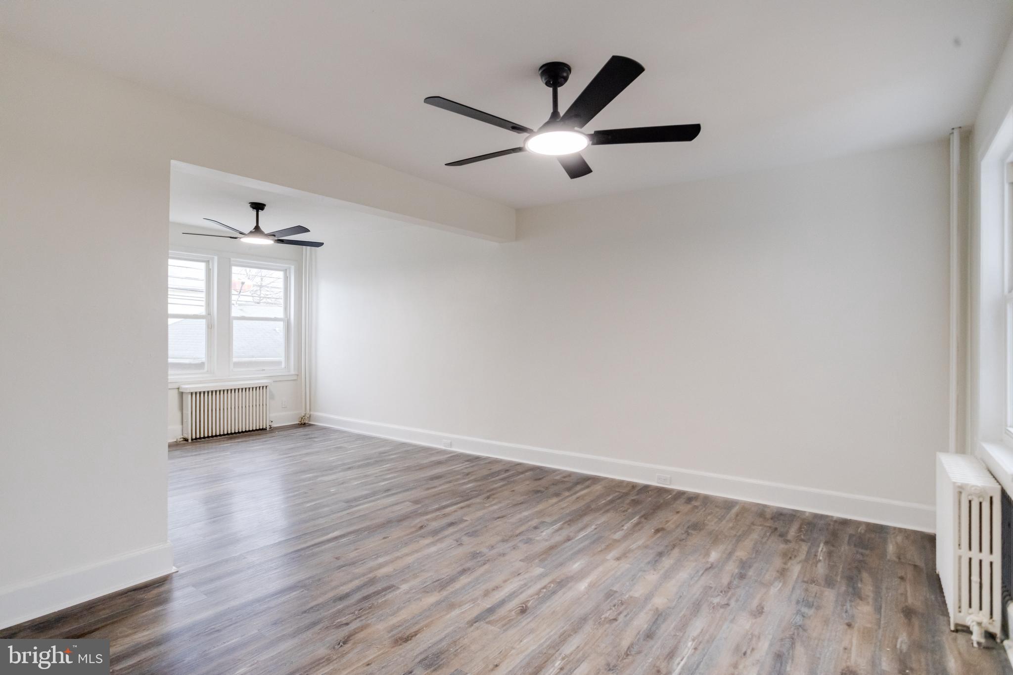 44 Shipway Baltimore, MD 21222 - Photo 4 of 53 an empty room with wooden floor ceiling fan and windows