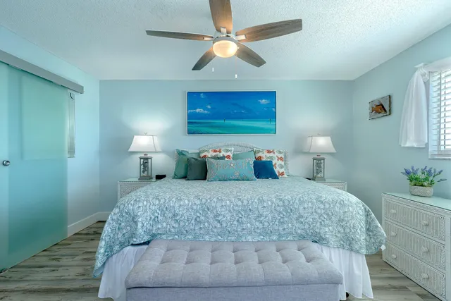 a bedroom with a large bed and a chandelier