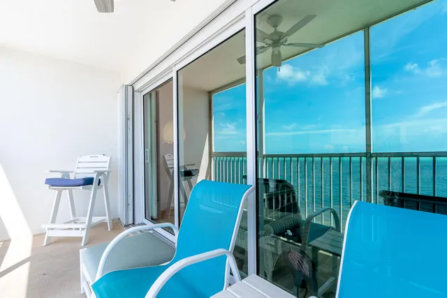 a balcony with chairs and a potted plant on a table