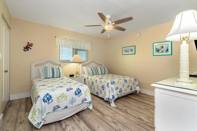a bedroom with two beds and painting on the wall
