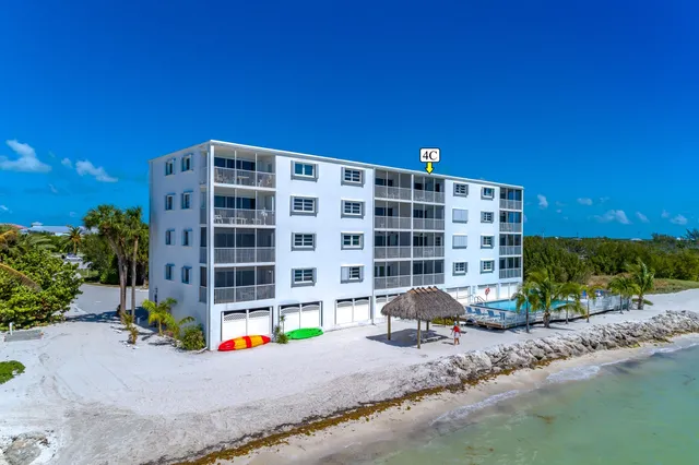 a front view of a building with glass windows and yard