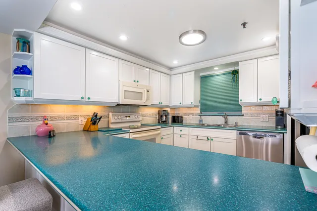 a kitchen with stainless steel appliances a stove top oven a sink dishwasher and cabinets with wooden floor