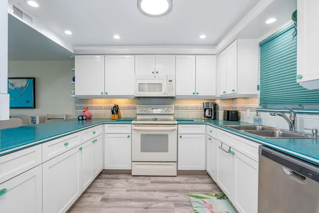 a kitchen with cabinets appliances a sink and a counter top space