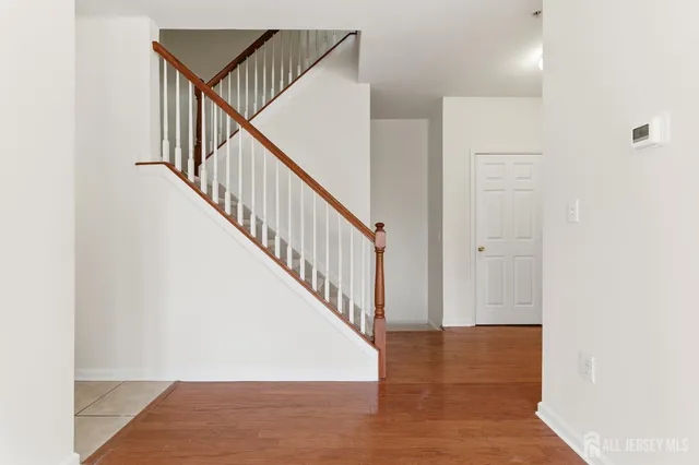 a view of staircase with white walls and a mirror
